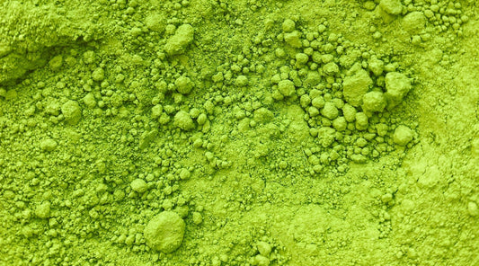 Close-up image of vibrant green matcha powder, showcasing its fine texture and natural clumps, ideal for illustrating the freshness and quality of matcha.